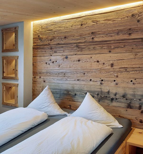 Berggasthaus Gitschenen Doppelzimmer mit Holzbett und weisser Bettwäsche