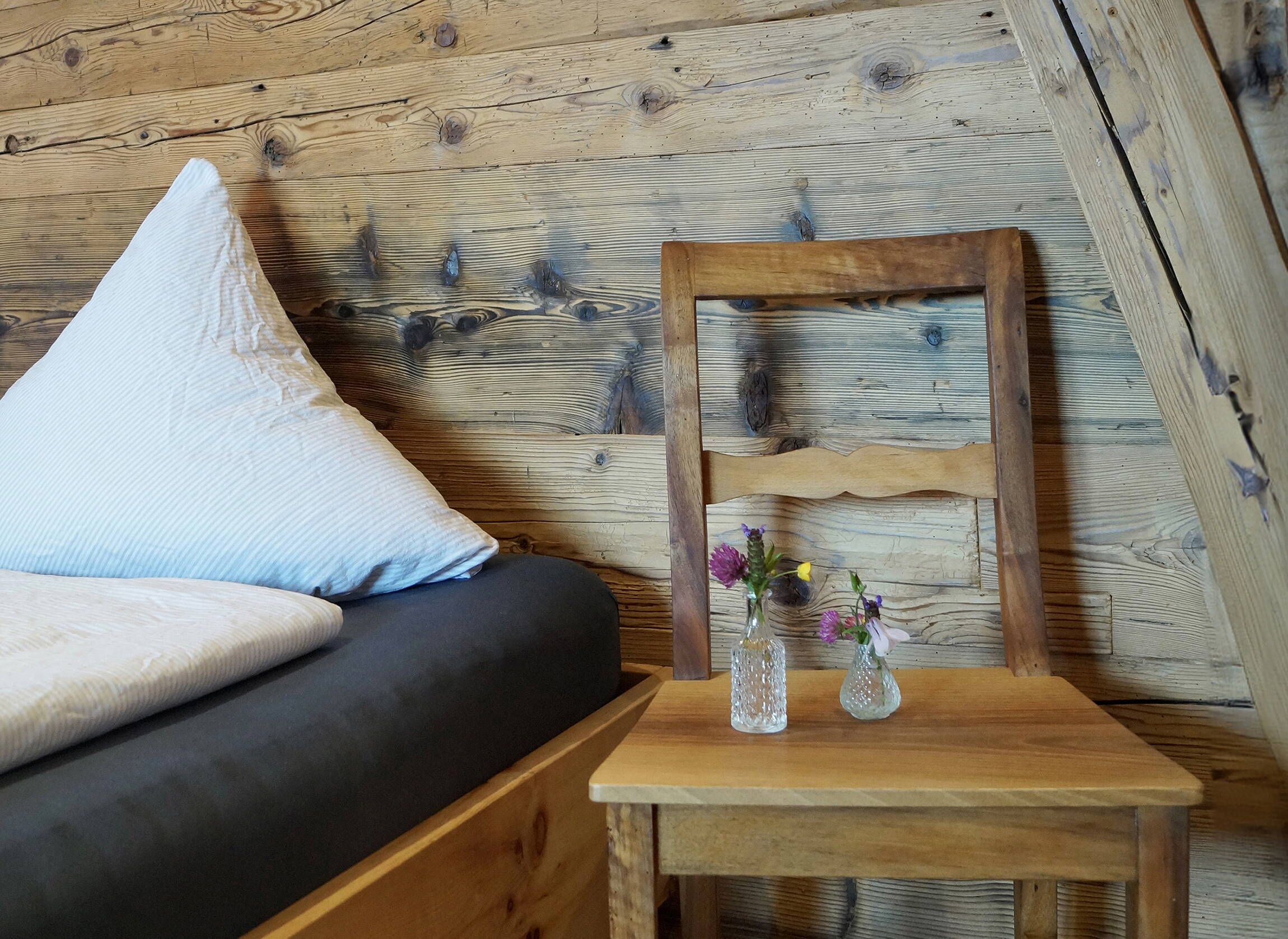 Berggasthaus Gitschenen Zimmer Berggasthaus Gitschenen, Zimmer mit Stuhl auf Nachttisch, Blumenstraus mit Wildblumen